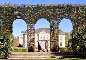 Ivy-covered arches in the Musée Rodin garden, the museum beyond