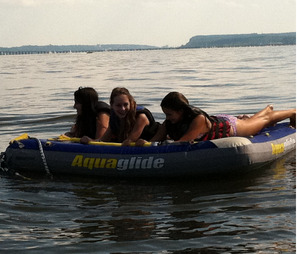 Three girls lying on an inflatable tube on the water