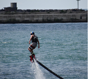 Someone hovering above the water on a flyboard