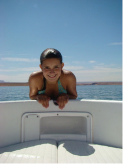 A girl leaning on the bow of a boat, smiling