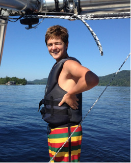 A boy in a life jacket standing on a boat